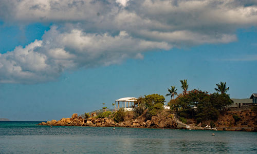 Scenic view of sea by buildings against sky