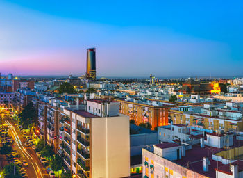 High angle view of illuminated cityscape against sky at night