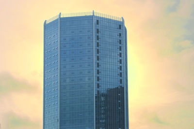 Low angle view of modern building against sky during sunset