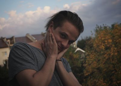 Portrait of smiling man sitting against sky