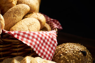 Close-up of food with wicker basket on wooden table against black background