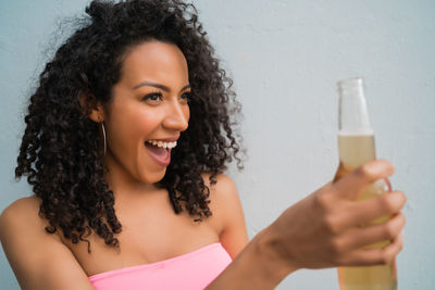 Portrait of a smiling young woman holding glass