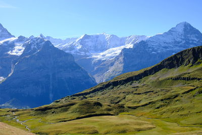 Scenic view of snowcapped mountains against clear blue sky