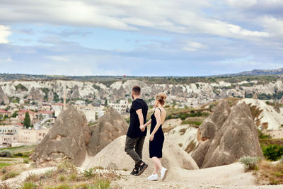 Panoramic view of man and rock formations against sky