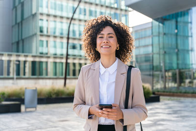 Young woman using mobile phone in city