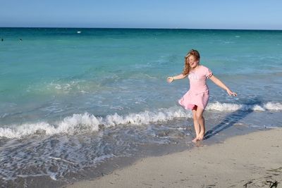 Full length of boy on beach against sky