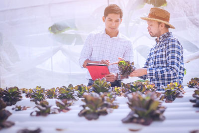 Young man and woman with flowers on plants