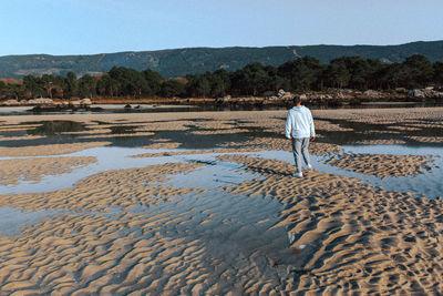 Rear view of man walking on beach