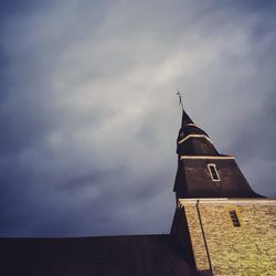 Low angle view of bell tower against cloudy sky