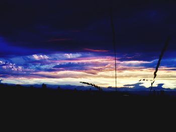 Silhouette landscape against dramatic sky during sunset