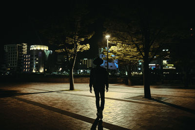 Full length of woman walking in city at night