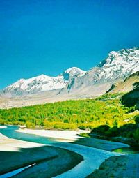 Scenic view of lake and mountains against blue sky