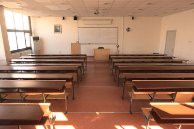 Empty chairs and tables in illuminated room