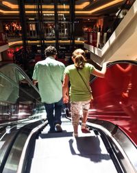 Full length of woman standing on escalator