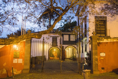 Illuminated building by street at night