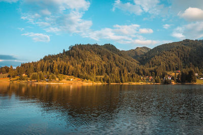 Scenic view of lake by mountains against sky