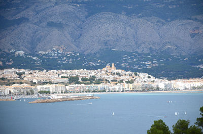 High angle view of townscape by sea against sky