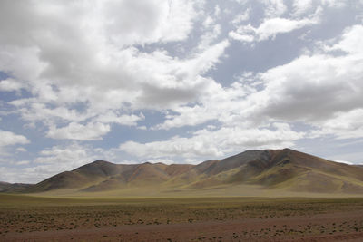 Beautiful mountains and red plateau meadows under the blue sky and white clouds