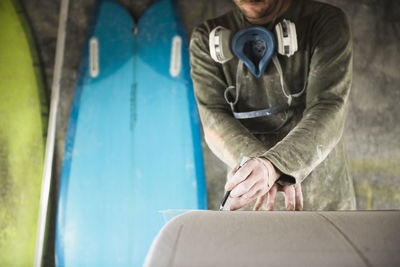 Surfboard shaper measuring a new design