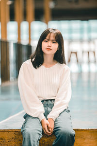 Portrait of young woman sitting outdoors