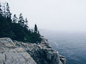 Scenic view of cliffed coast in foggy weather