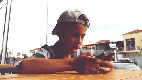 Boy using phone at table