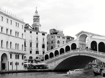 Arch bridge over canal against buildings in city