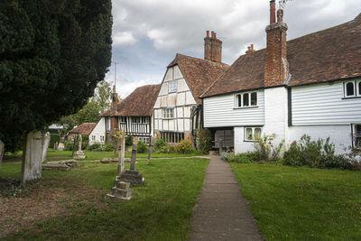 Houses amidst trees and buildings against sky