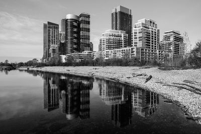 Reflection of building in lake against sky