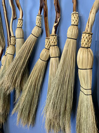 Close-up of brooms hanging against blue wall on granville island vancouver 