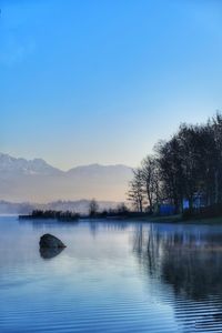 Scenic view of lake against clear blue sky