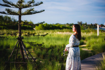 Woman standing on field against sky