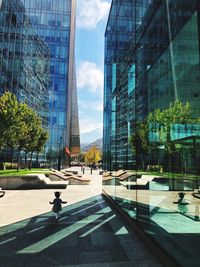 Modern buildings against sky seen through glass window