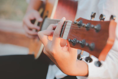 Midsection of man playing guitar