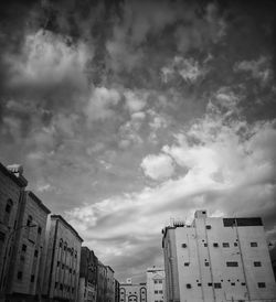 Low angle view of buildings against cloudy sky