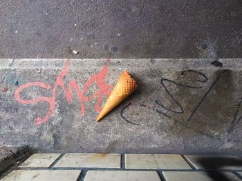 High angle view of ice cream cone on sidewalk by road