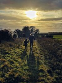 People on field against sky during sunset