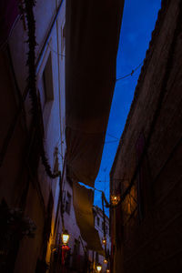 Low angle view of illuminated buildings against sky at night