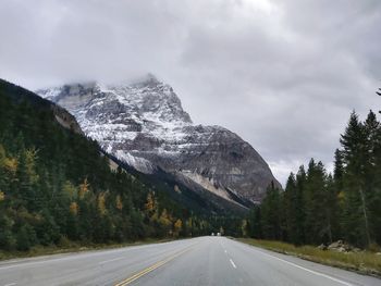 Road amidst snowcapped mountains against sky