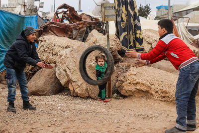 Boys playing with tire outdoors