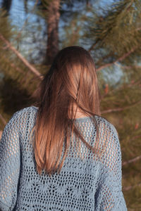 Rear view of woman with hair against trees