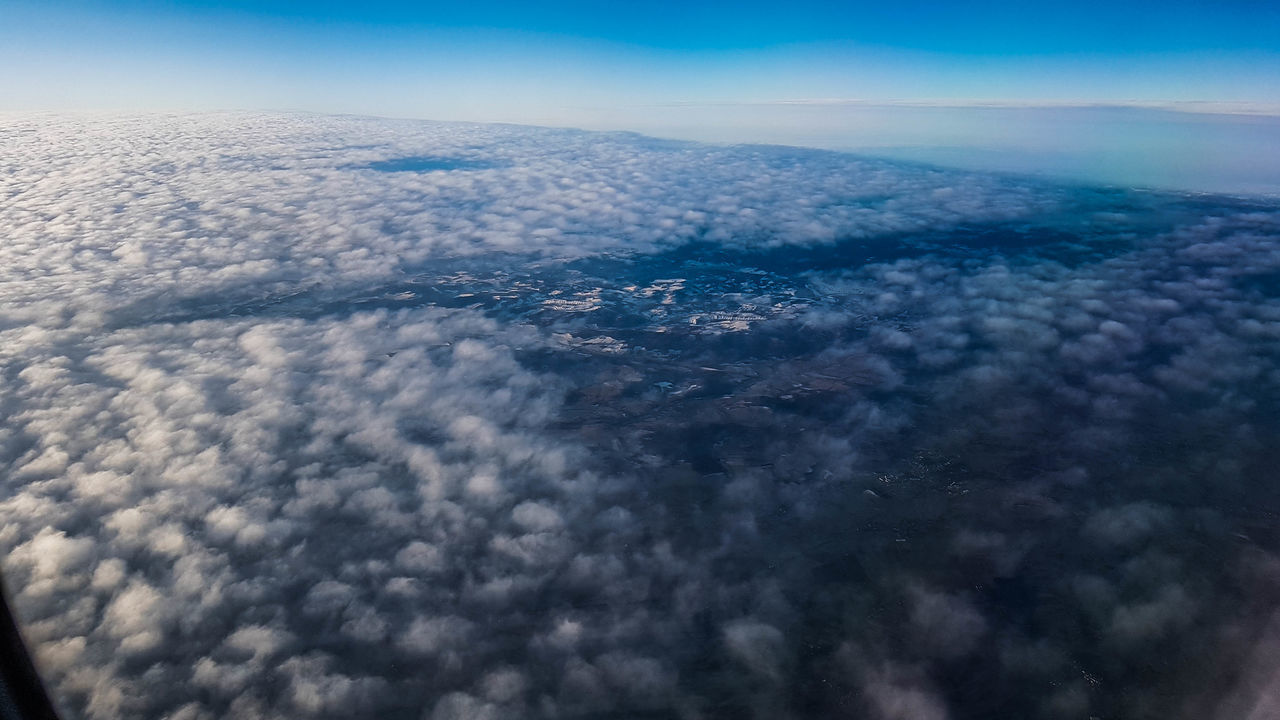 AERIAL VIEW OF CLOUDSCAPE OVER AIRPLANE WING