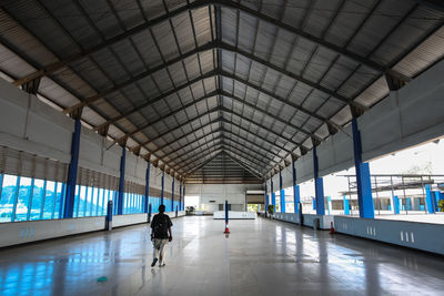 Rear view of man walking at railroad station