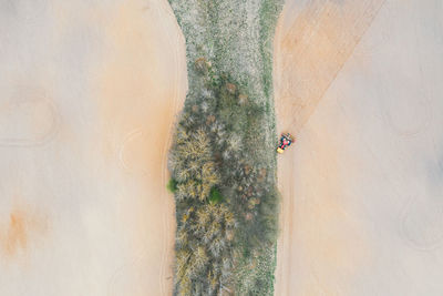 Lonely tractor on agricultural field with rows of plowed soil