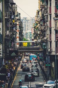 Vehicles on road along buildings in city