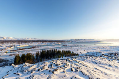 Scenic view of snowcapped landscape against clear blue sky