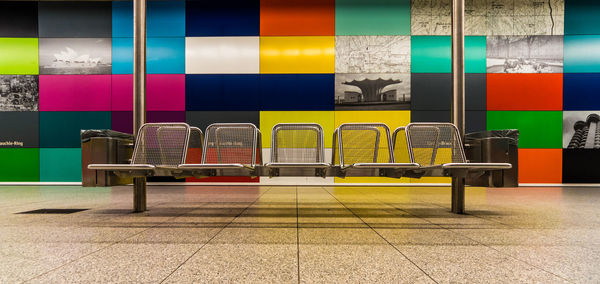 Empty seats on platform against colorful wall at munich u-bahn