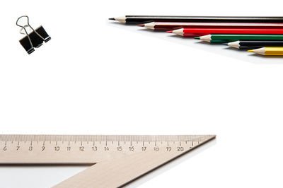 High angle view of pencils on table against white background