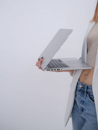 Midsection of woman using laptop on white background
