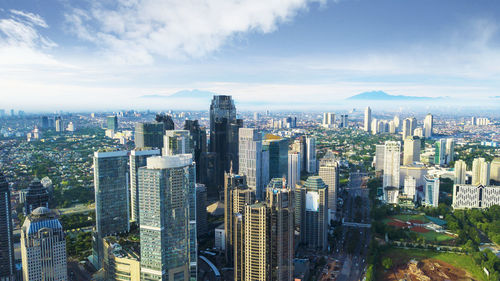 Aerial view of buildings in city against sky